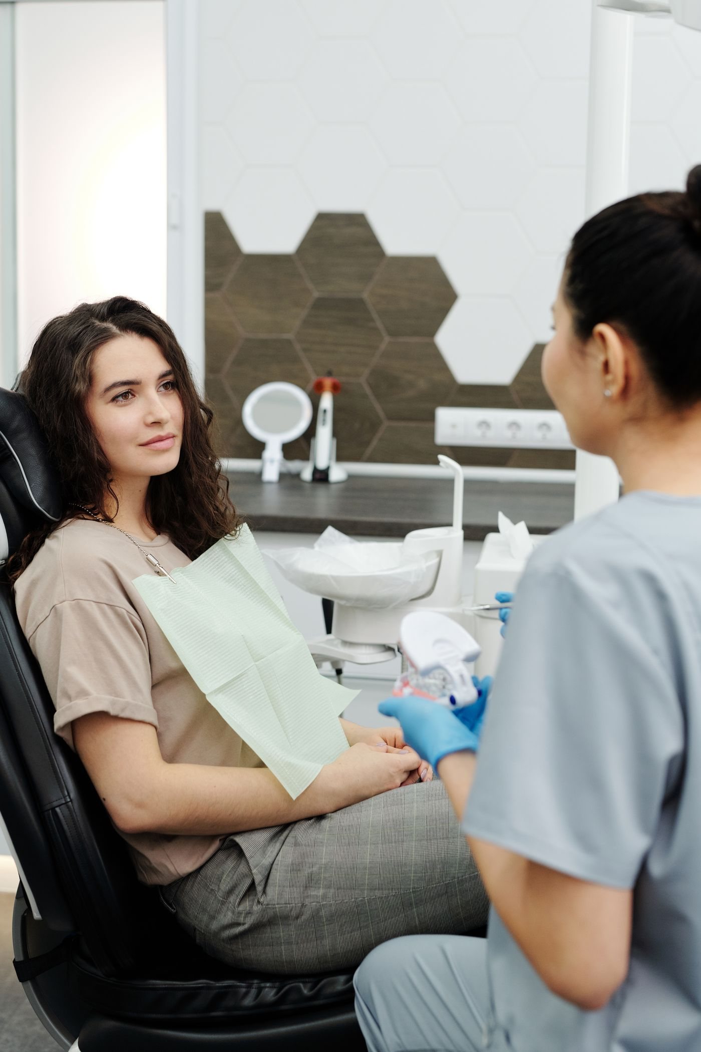 A patient seated and relaxed, talking with a clinician beside the chair.